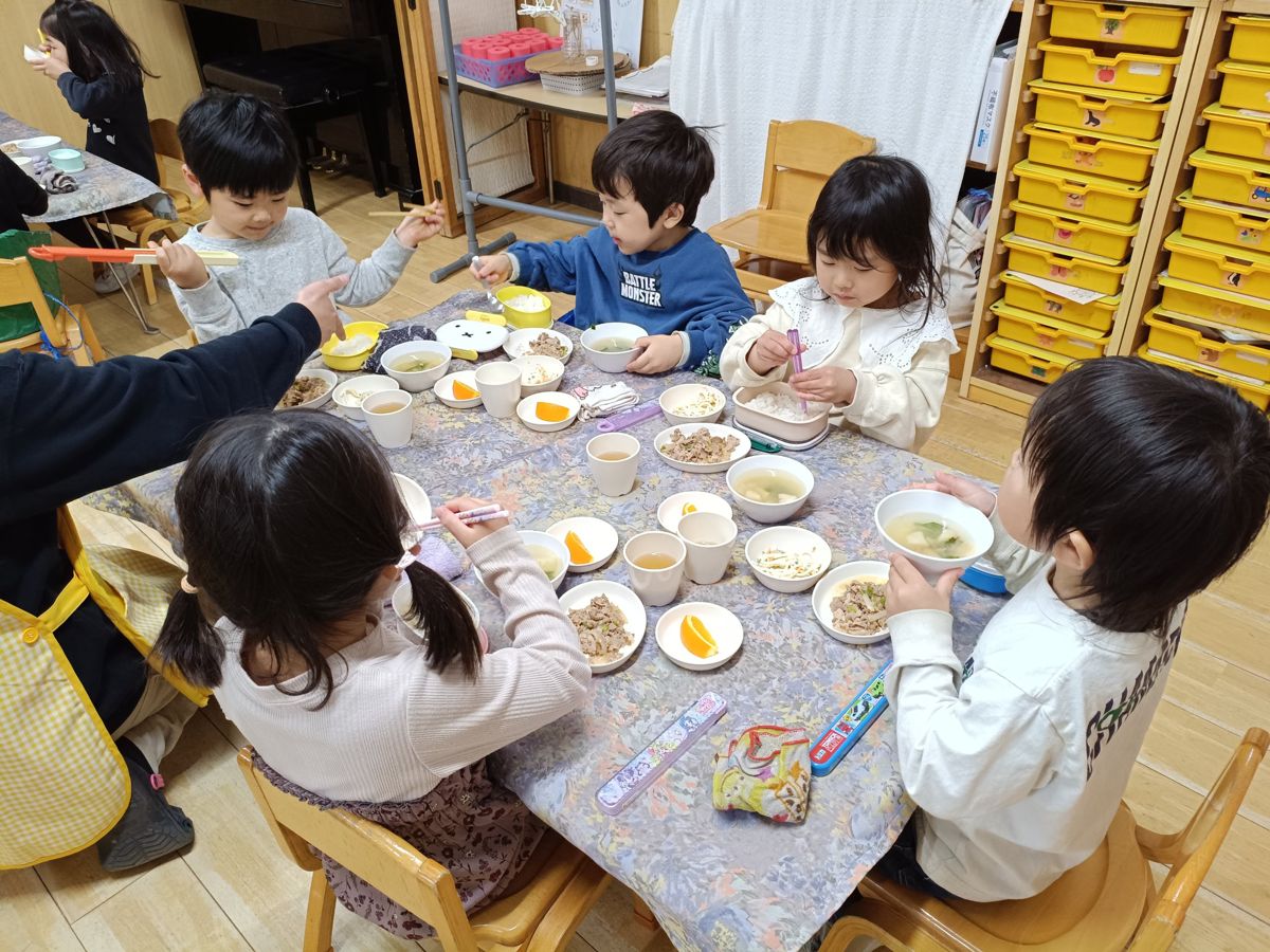 テーブルを囲んで給食を食べる子どもたち
